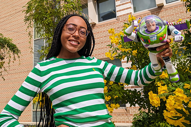 Communications Specialist II Janae Jordan holding Buzz Lightyear action figure