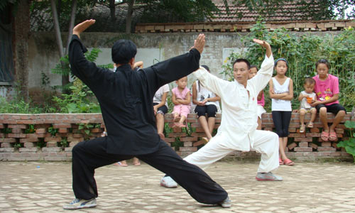 Boxing practice in village with children onlooking