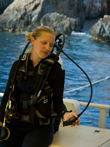 female in scuba gear sitting in boat