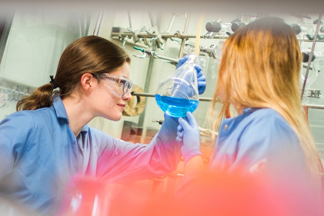 Chemistry student inspecting a flask of chemicals.