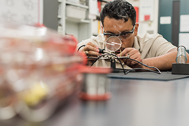 technician soldering wires in workshop