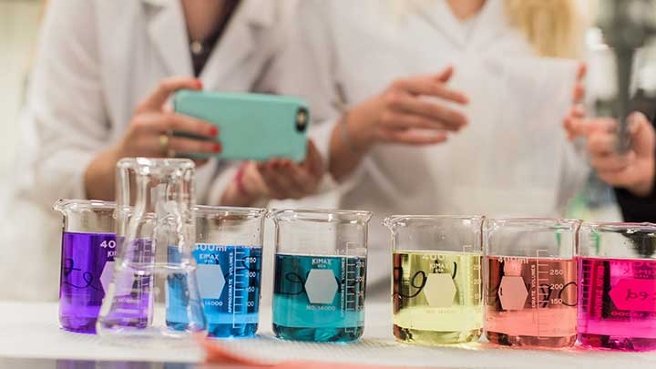 multiple beakers each filled with the color of the rainbow on the display