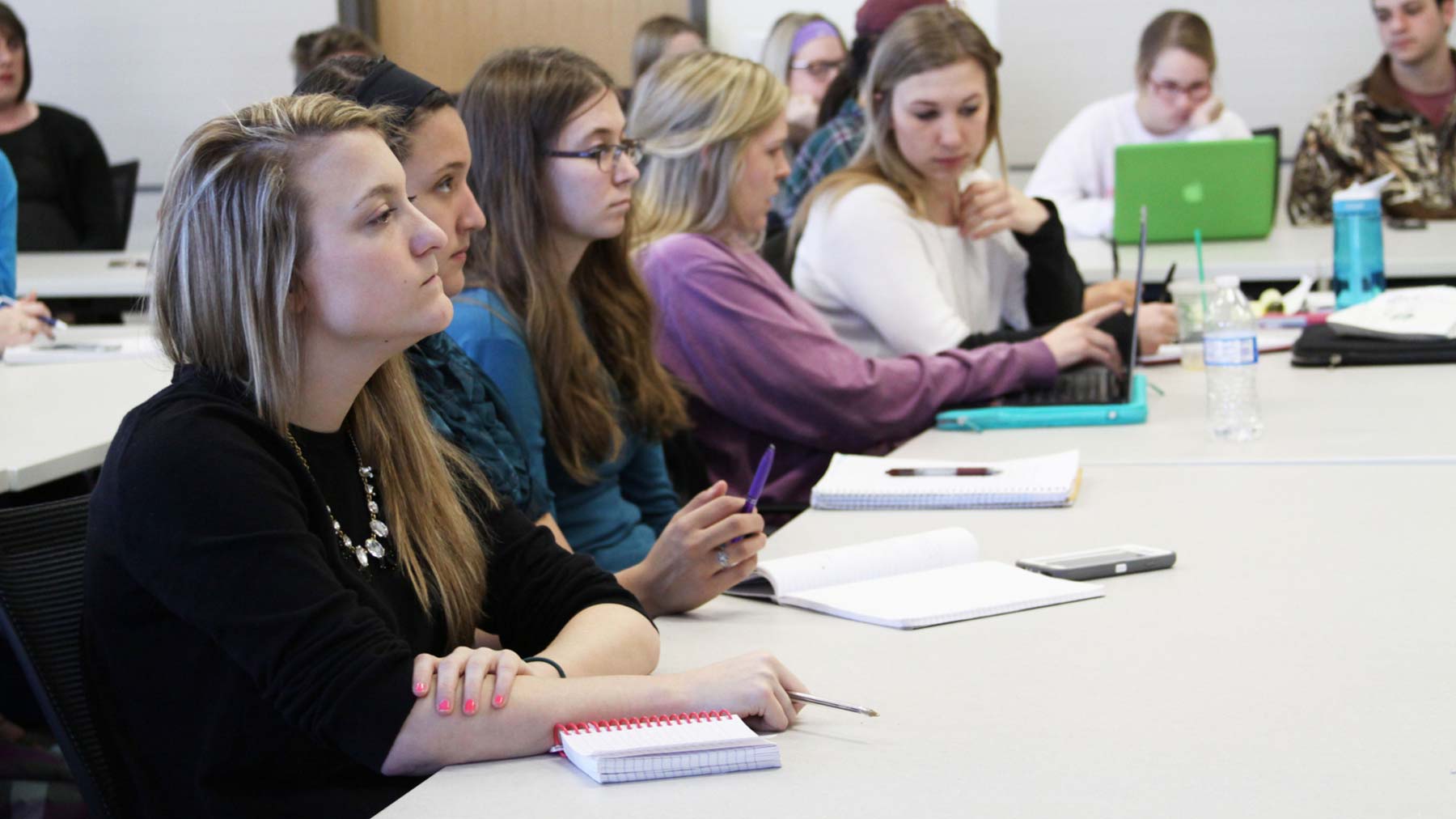 Students taking notes and listening to a lecture