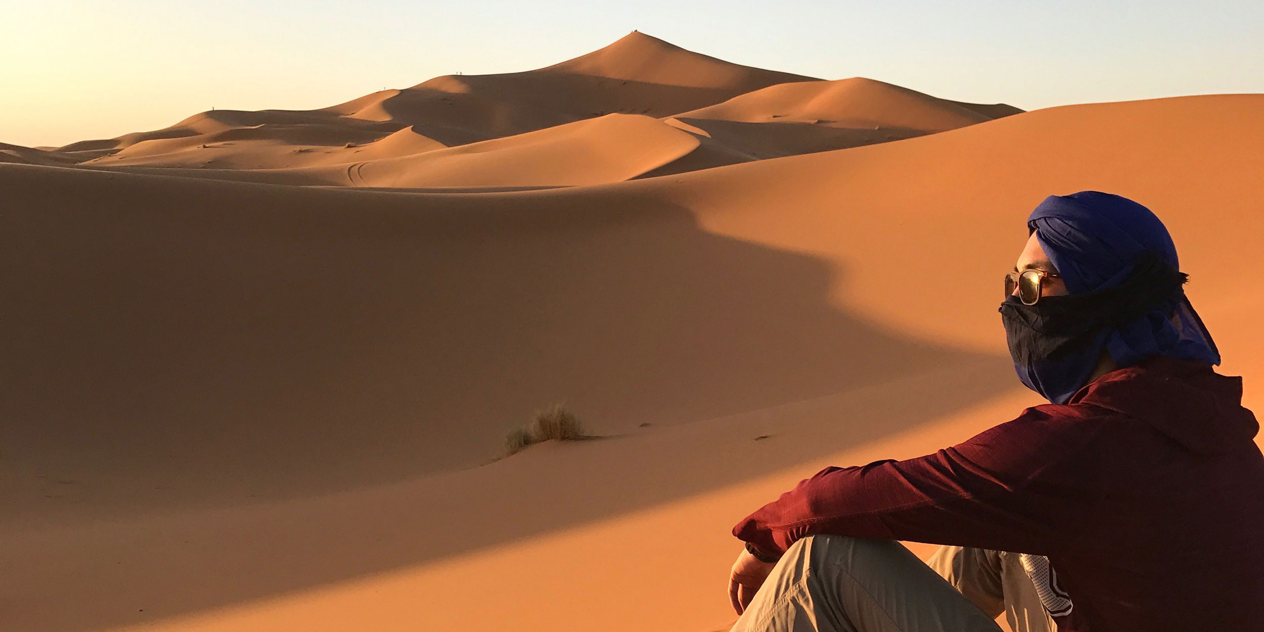 Student sitting sand dunes