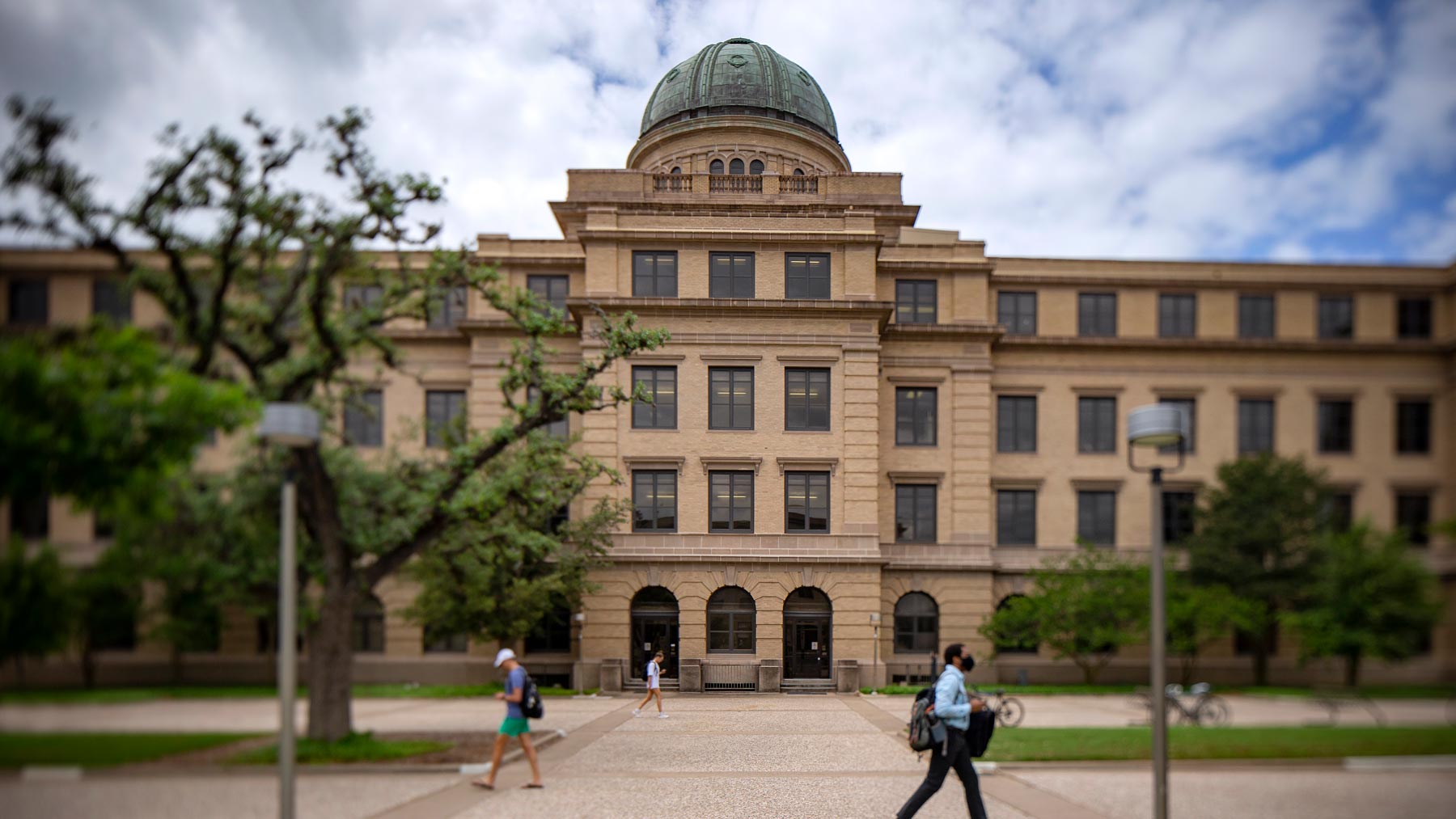 People walking past the Academic Building on campus.