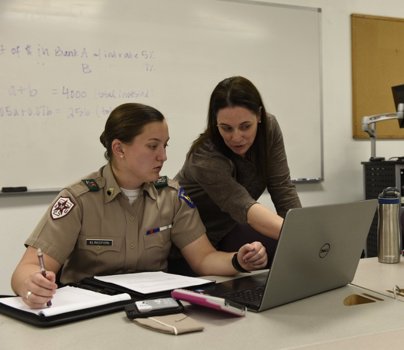 A woman helps a student in the math learning center.