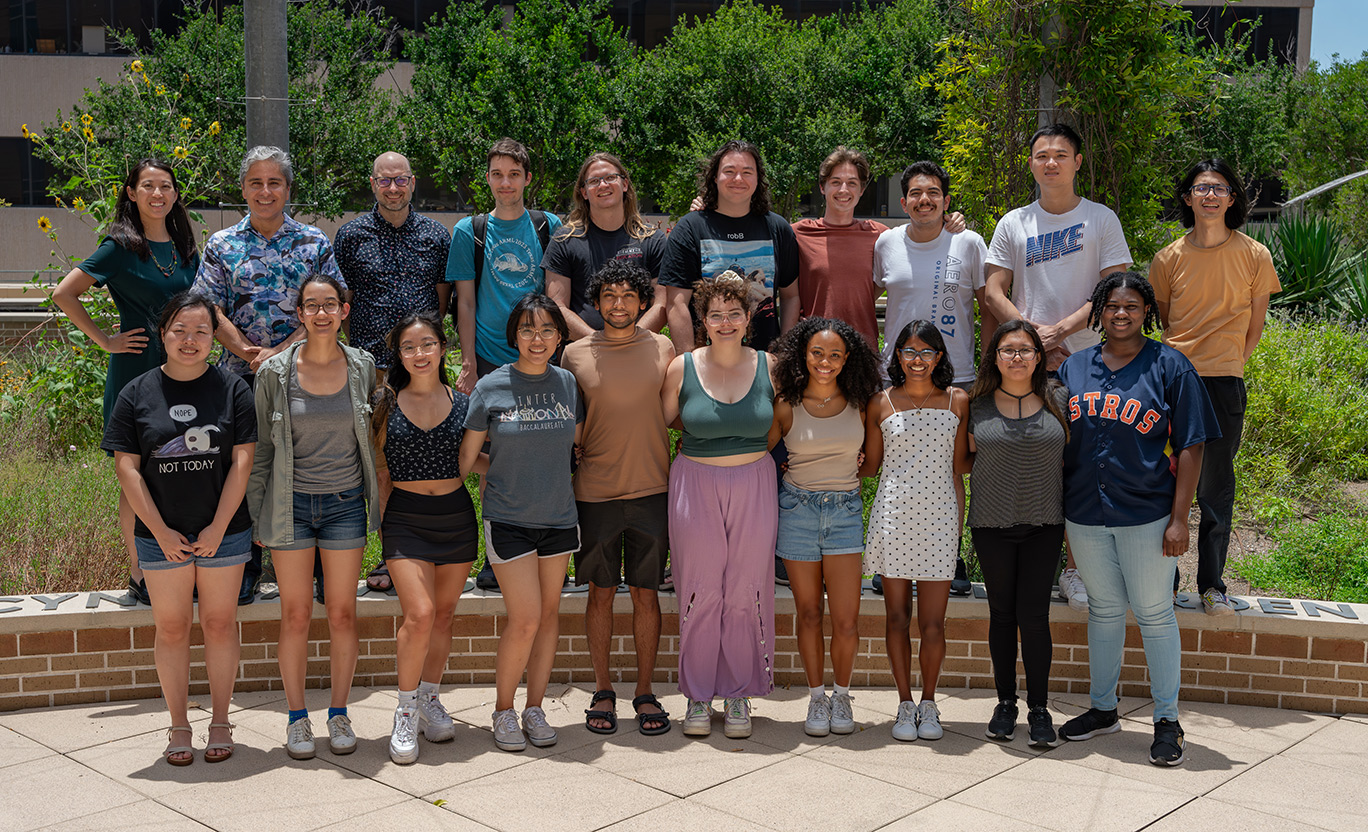 twenty people of mixed demographics standing shoulder to shoulder in two rows for outdoor photo