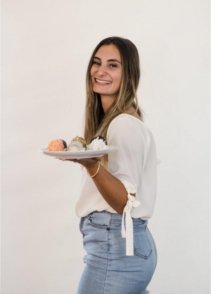 Woman holding plate of chocolate strawberries