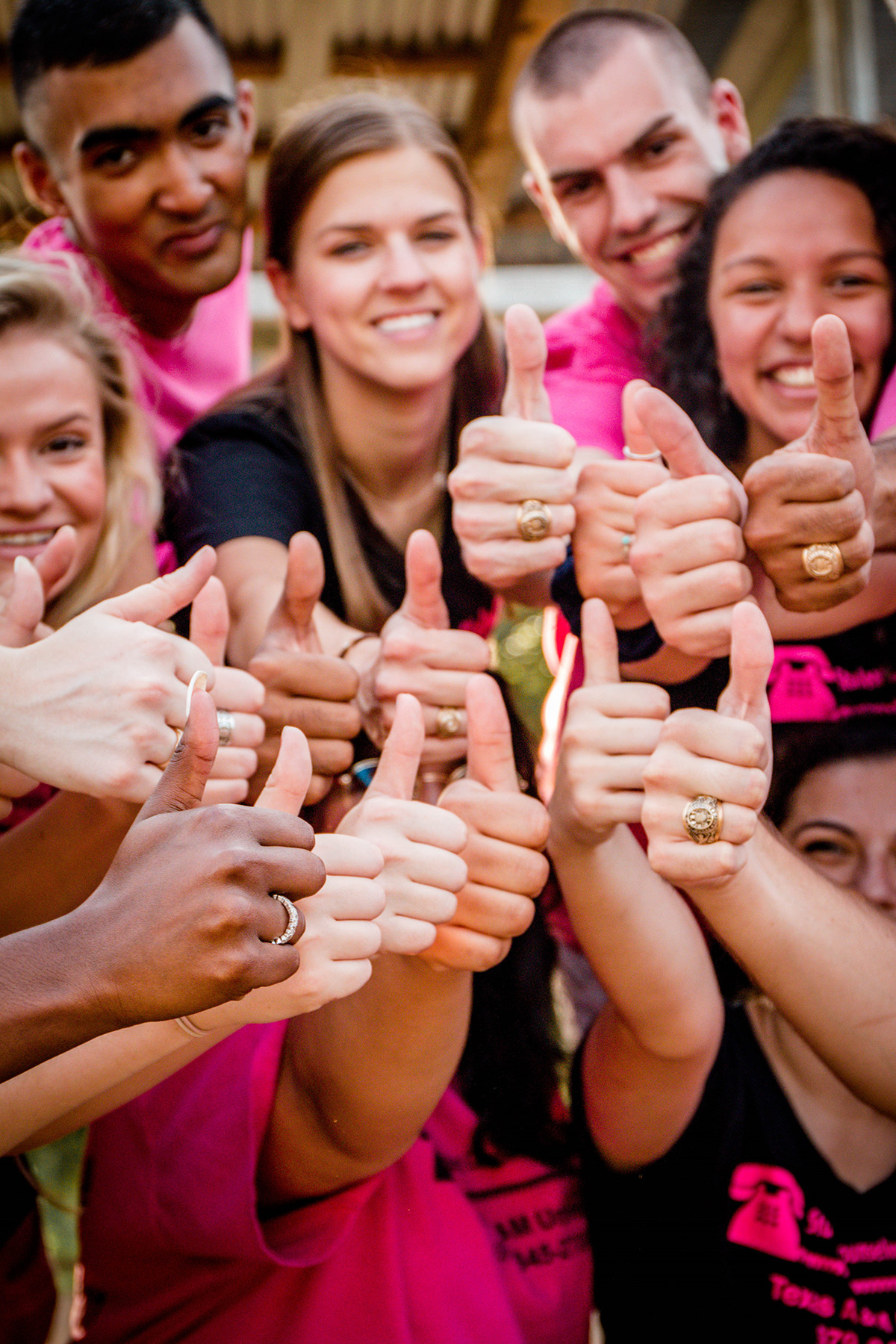 Group of Texas A&amp;M students flashing the classic thumbs-up gig 'em sign