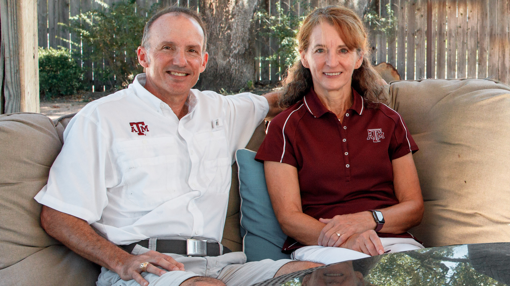 Texas A&M University former students Kerry and Angela Stein smile for the camera while sitting in an outdoor area outside their home in College Station, Texas