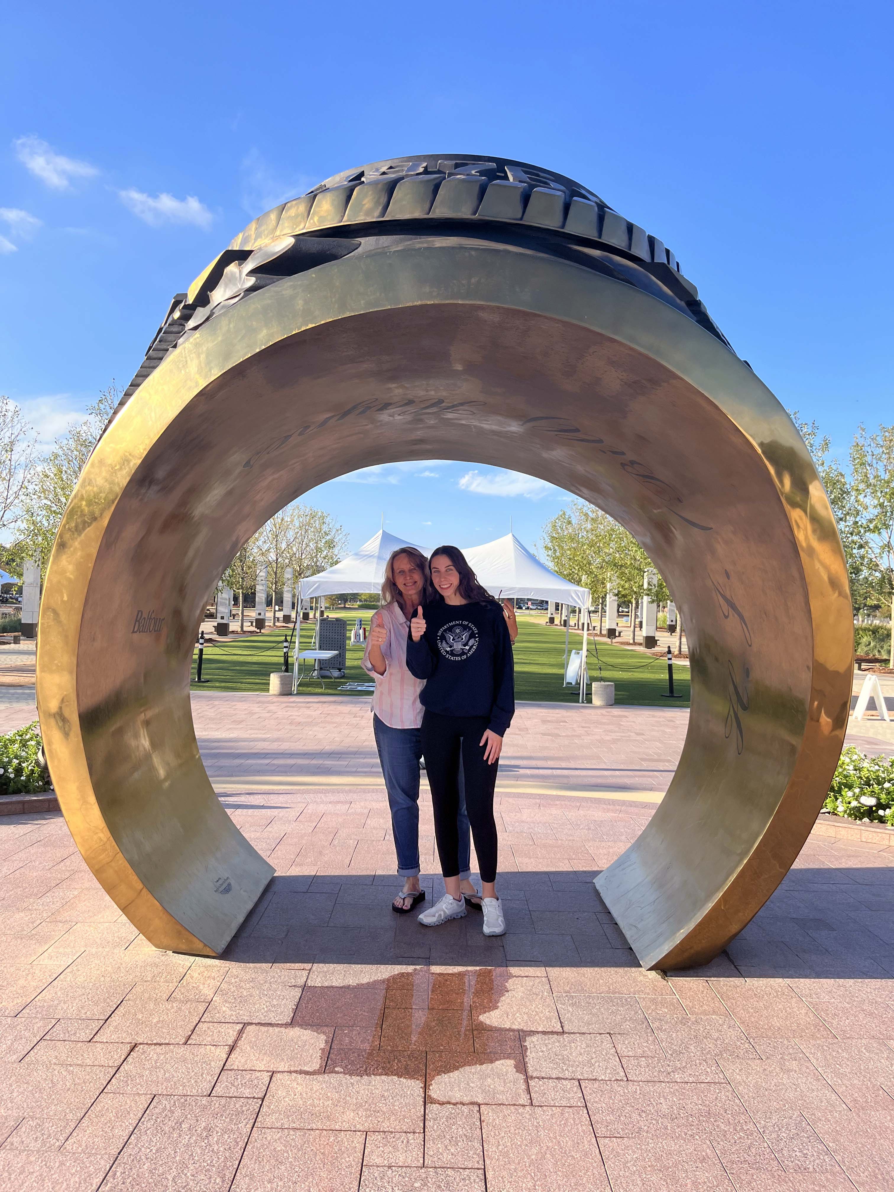 SarahBeth (right) and Shari Boothe pose together inside the giant Aggie Ring outside the Clayton Williams Jr. Alumni Center on the Texas A&amp;M University campus