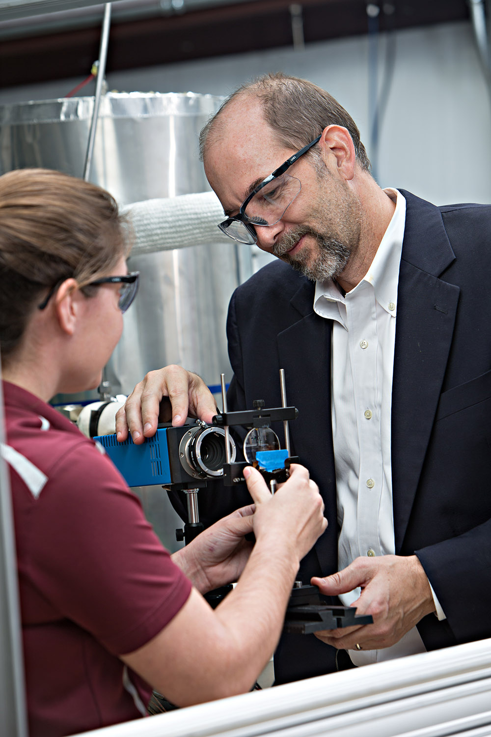 Texas A&amp;M University chemist Simon North, wearing goggles and working with a student in his research laboratory