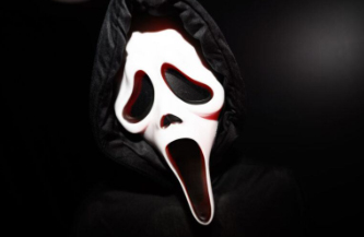 Close-up of the distorted white face, black eyes and gaping mouth of the villain "Ghostface" from the popular "Scream" movie series