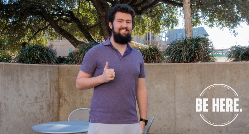 David Cates standing outdoors giving a thumbs-up with the text "BE HERE." displayed in the lower right corner.