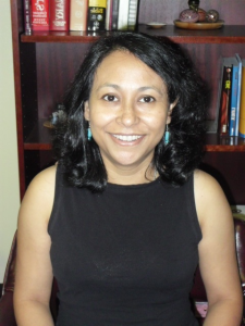 Woman smiling at camera with black dress on.