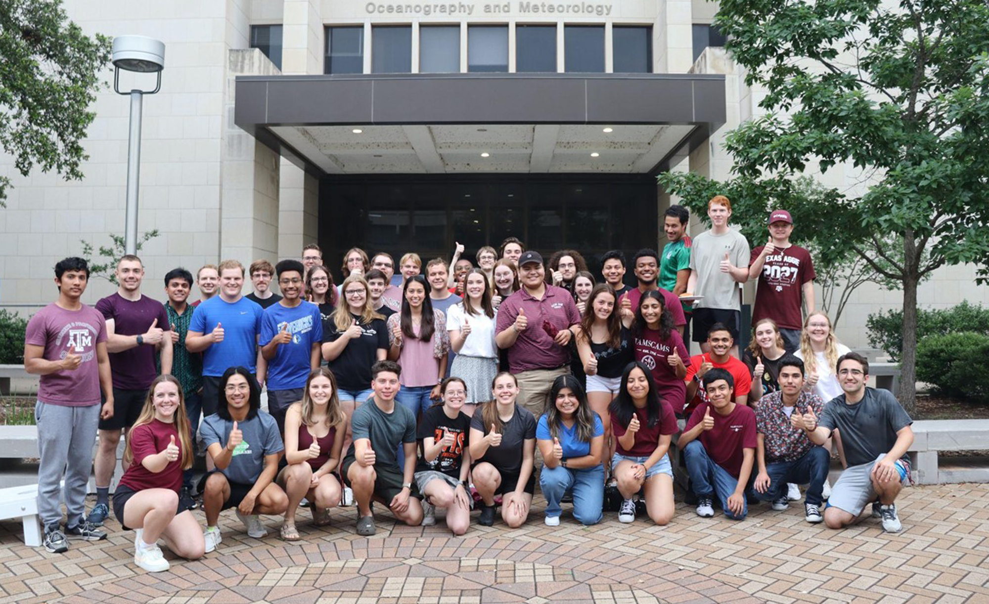 A group of TAMSCAMS students standing in front of the Oceanography and Meteorology building at Texas A&amp;M University. The photo is from May 2024