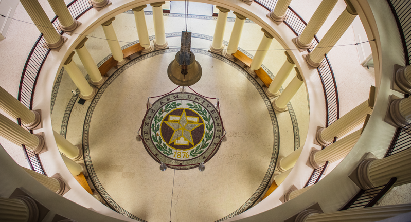 Overhead view of a rotunda floor with Texas A&M University seal, surrounded by columns.