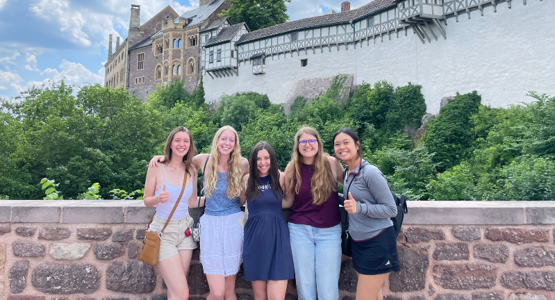 Five female Global Studies students standing in front of Wartburg Castle in Germany