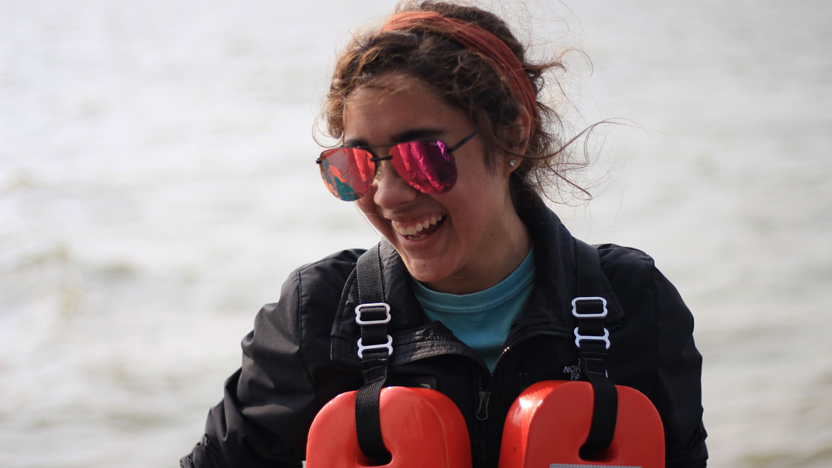 Female student candidly smiling while performing ship-based research