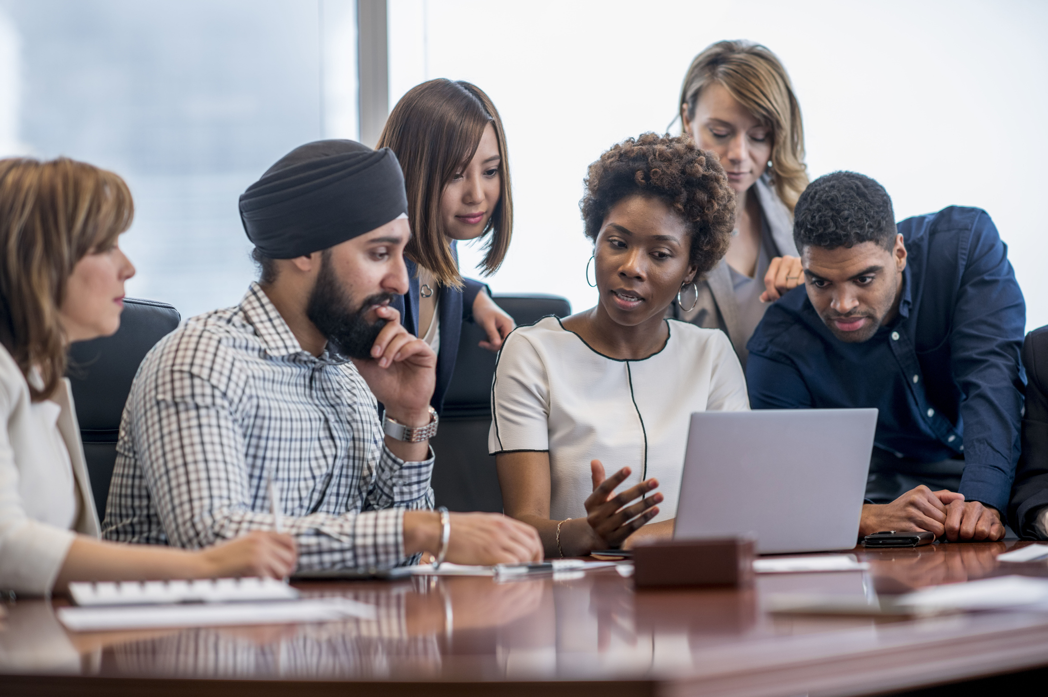 multi-ethnic group working around a laptop